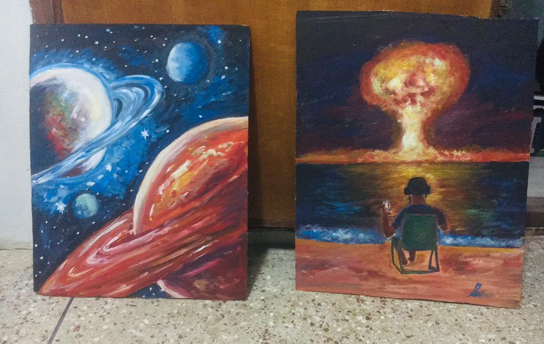 Two cosmic paintings leaning against a studio wall